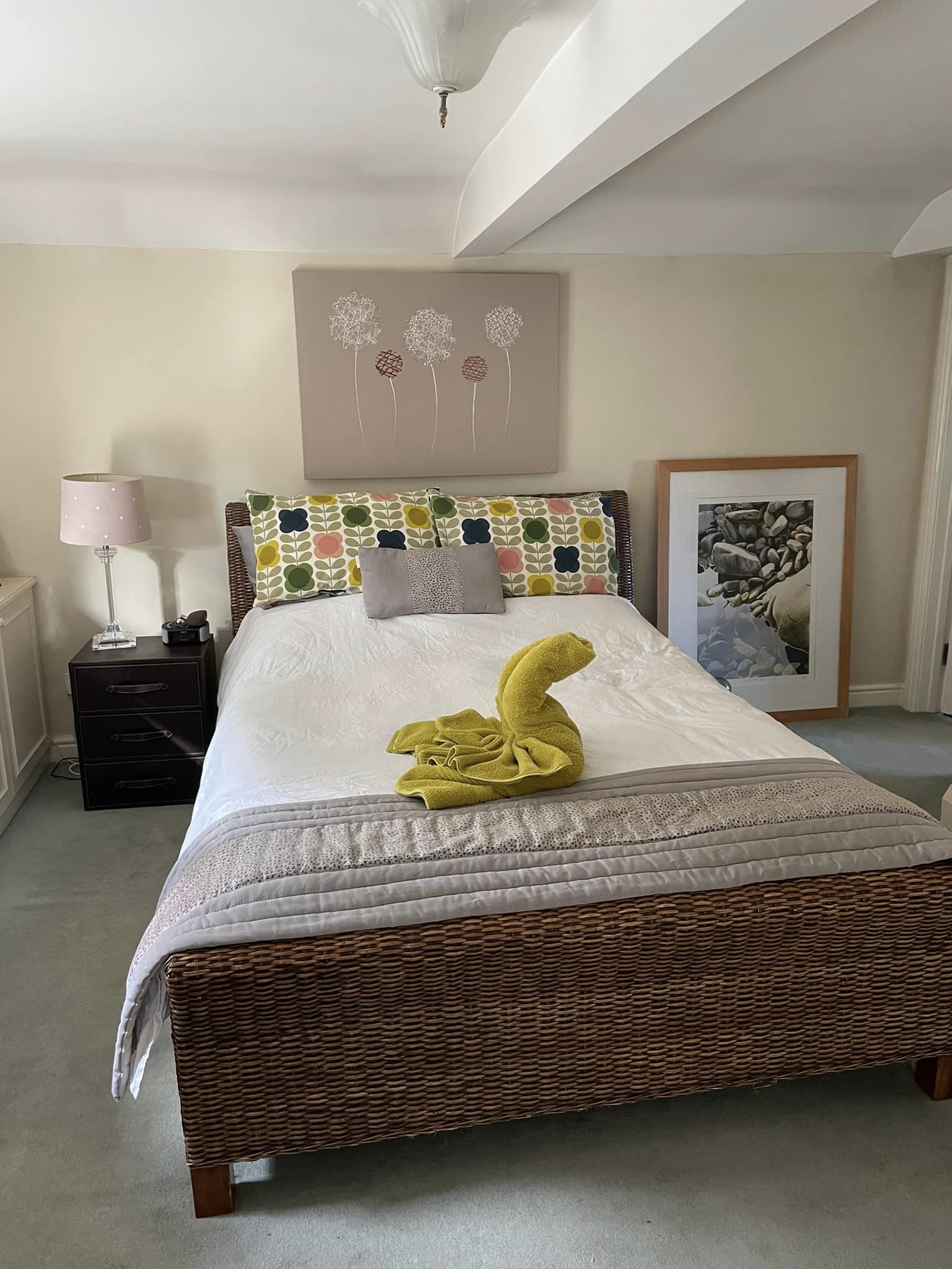 Woven style wooden bed with swan shape green towel